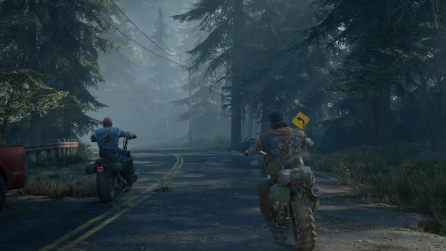 Deacon St. John en moto sur une route forestière, image tirée de Days Gone Remastered sur PlayStation 5.